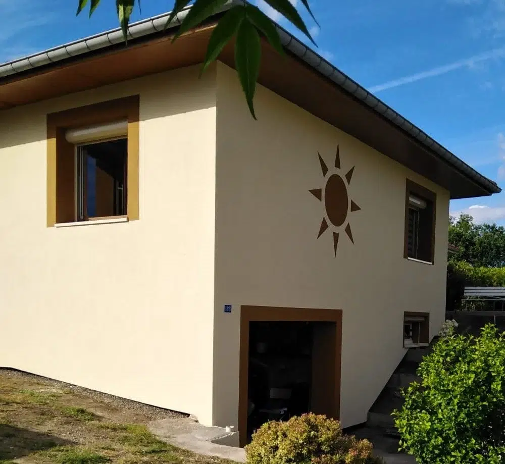 Maison beige avec un motif de soleil